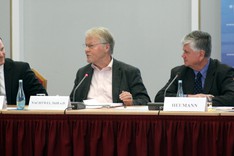 Drei Herren sitzen an einem Tisch und diskutieren.