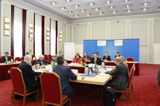 Die acht Experten der Regierungskommission sitzen sich an Tischen im historischen Saal der BAKS gegenüber.