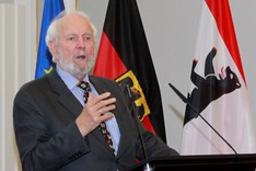 Ein Herr mit dunklem Anzug steht an einem Rednerpult.