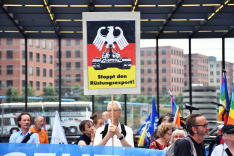 Eine Gruppe Menschen demonstriert gegen Waffenexporte mit bunter Beschilderung.