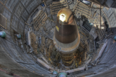 Der Betrachter blickt von oben in ein geöffnetes Raketensilo, in dem eine ausgemusterte Titan II-Atomrakete zu ihm aufragt.