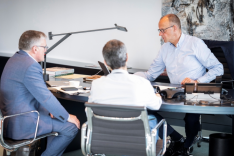 Bundeskanzler Friedrich Merz sitzt mit Regierungssprecher Stefan Kornelius und dem Abteilungsleiter 2 des Bundeskanzleramts Günter Sautter an einem Schreibtisch und spricht in ein digitales Gerät.