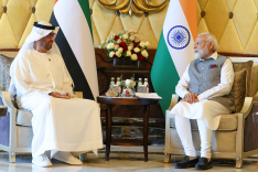 Der indische Premierminister Modi und der designierte COP 28 Präsident und CEO der Abu Dhabi National Oil Company Al Jaber sitzen vor Flaggen ihrer Staaten und unterhalten sich. 