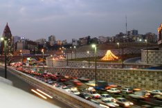 Das Foto zeigt eine vielbefahrene Autoverkehrsstraße in Teheran in der Dämmerung.