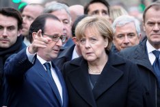 Frankreichs Präsident Francois Hollande und Deutschlands Bundeskanzlerin Angela Merkel stehen gemeinsam mit EU-Rats Präsident Donald Tusk beim Solidaritätsmarsch am 14. Januar 2015 für die Opfer der Anschläge auf das Satiremagazin Charlie Hebdo