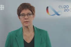 Annegret Kramp-Karrenbauer spricht vor einer hellblauen Wand zum Zuschauer.