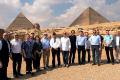 Eine Menschengruppe steht vor den Pyramiden und der Sphinx in Giseh, Ägypten.