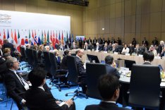 Zahlreiche Außenminister der G20-Mitgliedsstaaten sitzen um einene großen Konferenztisch vor einer Pressewand mit der Aufschrift "G20 Germany".
