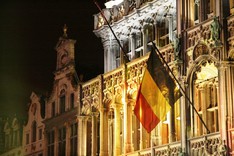 An einer Gebäudefassade weht die Nationalflagge Belgiens