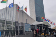 Hinter einer Reihe von Staatsflaggen ragt das Hauptgebäude der Vereinten Nationen in New York City auf.