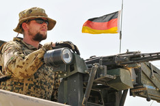 A German soldier of the Camp Marmal Force Protection Group mans a machine gun atop a vehicle, North Afghanistan, August 2011
