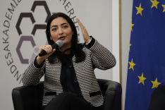 Bundesministerin Reem Alabali Radovan spricht an der BAKS gestikulierend in ein Mikrofon; rechts von ihr ist die Flagge der Europäischen Union zu erkennen.
