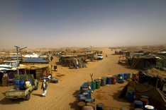 Ein provisorisches Flüchtlingslager erstreckt sich über ein Wüstenplateau bis zum Horizont.