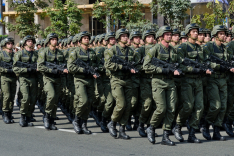 Bewaffnete ukrainische Soldaten marschieren in Formation über eine Straße in Kiew