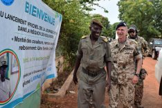 Ein malischer und ein deutscher Soldat vor einem Plakat in Mali.