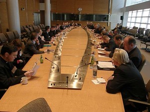Viele Personen sitzen an einem großen Konferenztisch.