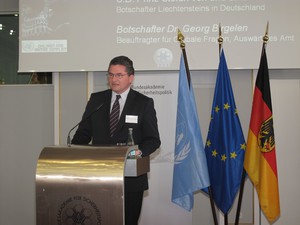 Ein Herr im Anzug steht an einem Rednerpult
