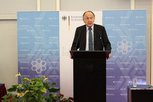 Ein Herr mit dunklem Anzug steht an einem Rednerpult.