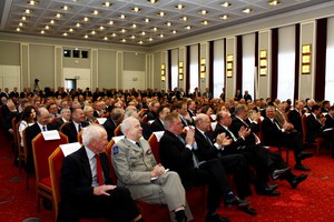 Das Publikum während der Festansprache. Der Saal ist gefüllt, im Hintergrund stehen weitere Zuhörer.