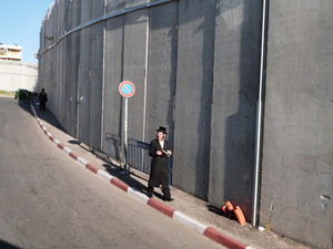 Ein orthodoxer Jude am Grab von Rahel, welches durch eine Mauer von der palästinensischen Stadt Bethlehem getrennt wird