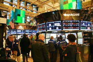 Börsensaal der New Yorker Börse mit vielen Bildschirmen, auf den Aktienkurse zu sehen sind. 