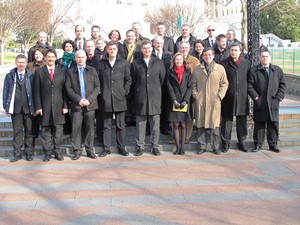 Gruppenbild mit 27 Damen und Herren in drei Reihen im Sonnenschein.