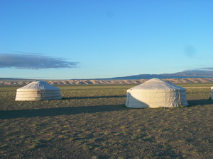 Landschaftsbild der mongolischen Steppe mit zwei traditionellen Jurten.
