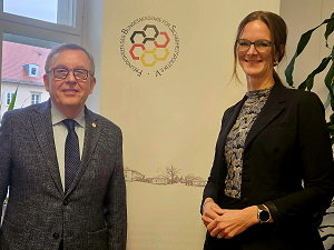 BAKS-Vizepräsident a.D. Armin Staigis und AKJS-Vorsitzende Nadine Ogiolda stehen vor einem Hintergrundaufsteller des Freundeskreises der BAKS e.V.