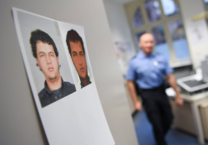 Das Bild zeigt Fahndungsfotos in einer Polizeiwache.