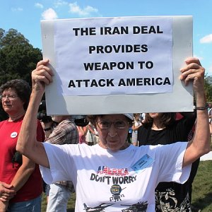 Eine Seniorin hält ein Schild hoch mit der Aufschrift: The Iran Deal provides weapons to attack America"