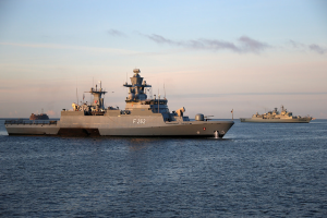 Zwei Kriegsschiffe fahren in mittlerem Abstand zueinander parallel langsam durch ruhige See.