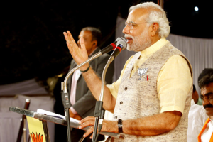 Narendra Modi spricht an einem Mikrofon.
