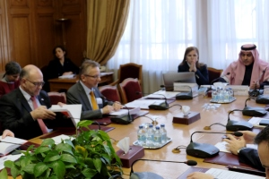 Mehrere Menschen sitzen um einen Konferenztisch.