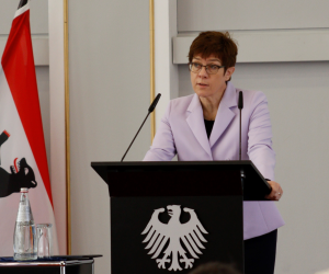 Annegret Kramp-Karrenbauer steht sprechend an einem Rednerpult mit dem Bundesadler darauf.