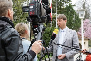 Prof. Dr. Dirk Helbing steht vor dem Gebäude der BAKS und gibt Fernsehjournalisten ein Interview; links im Bild stehen Kamera, Kameramann und eine fragende Reporterin, und von rechts außerhalb des Bildes hält ein Tonmann ein Mikrofon vor ihm hin.