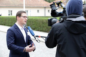 Dr. Sven Herpig gibt vor dem Gebäude der BAKS einem Fernsehteam ein Interview; rechts im Bild stehen die Kamera und ein Kameramann; von rechts außerhalb des Bildes wird ihm ein Mikrofon hingehalten.
