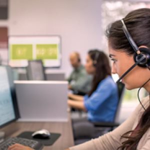 Profilbild einer Mitarbeiterin in einem Call Center mit Headset und PC