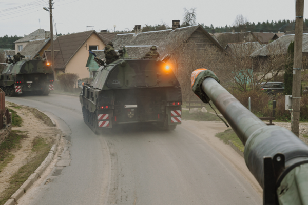 Panzerhaubitzen der Bundeswehr fahren durch ein Dorf in Litauen