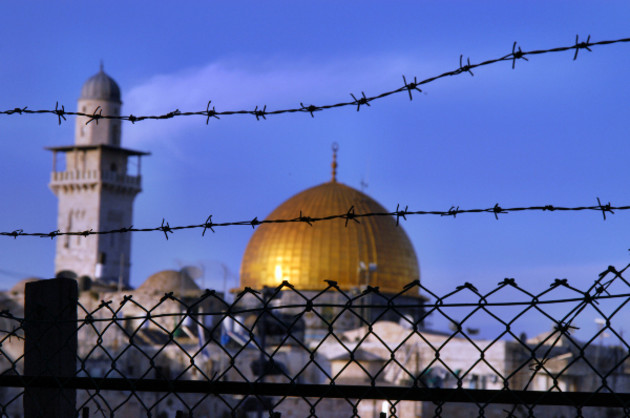 Im Vordergrund Stacheldraht, im Hintergrund der Tempelberg in Jerusalem mit der Goldenen Kuppel der Moschee