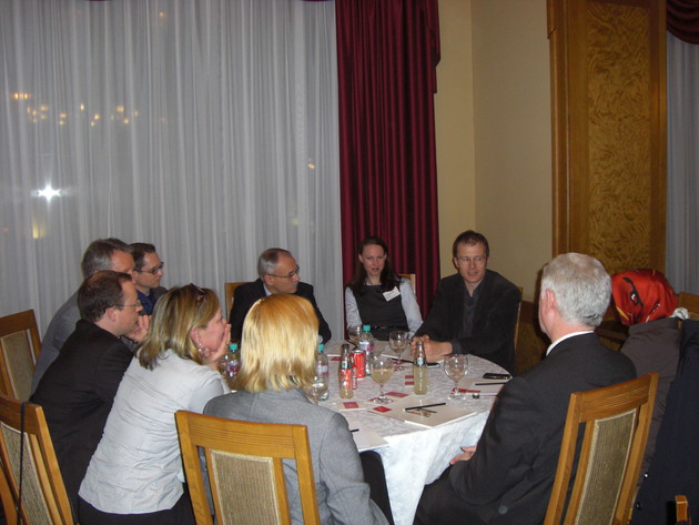 Eine Gruppe sitzt an einem Tisch und diskutiert