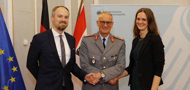 BAKS-Präsident Generalmajor Stahl, mittig stehend, schüttelt gleichzeitig jeweils die Hand von Tobias Lücke und der AKJS-Vorsitzenden Nadine Ogiolda, die beidseits neben ihm stehen.