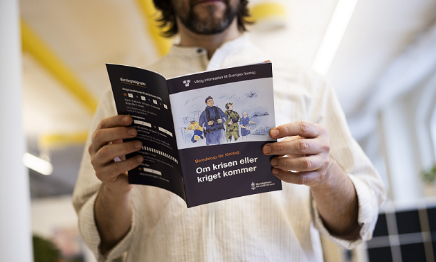 Foto: Schwedische Zivilschutzbehörde/Melker Dahlstrand Ein Mann liest die schwedische Broschüre Preparedness for businesses: In case of crisis or war im schwedischen Original.