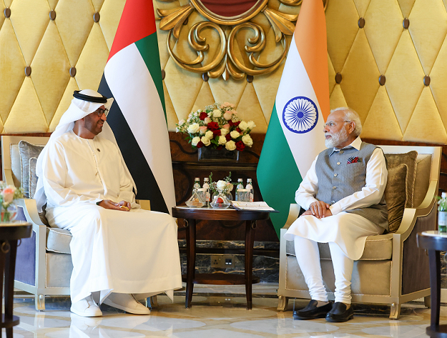 Der indische Premierminister Modi und der designierte COP 28 Präsident und CEO der Abu Dhabi National Oil Company Al Jaber sitzen vor Flaggen ihrer Staaten und unterhalten sich.
