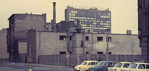 Straßenszene in Ostberlin in Mauernähe mit geparkten Wartburg- und Trabant-Pkws; Hinterlandmauer in der Schützenstraße, Ecke Charlottenstraße; im Hintergrund das Axel-Springer-Hochhaus in West-Berlin
