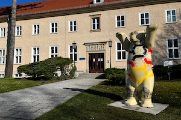 Blick auf ein Gebäude der BAKS. Im Vordergrund: Der BAS-Bär.