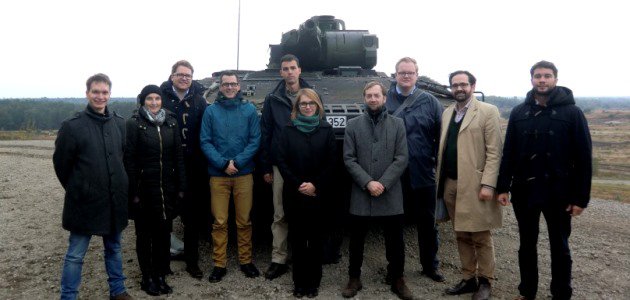 Die Mitglieder des Arbeitskreises \"Junge Sicherheitspolitiker\" vor einem Panzer der Bundeswehr.