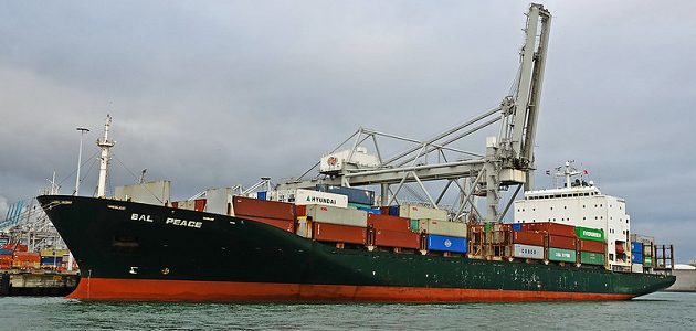Das Foto zeigt ein beladenes Containerschiff im Hafen.