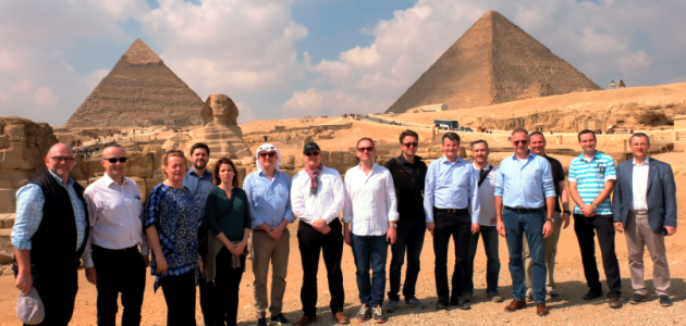 Eine Menschengruppe steht vor den Pyramiden und der Sphinx in Giseh, Ägypten.