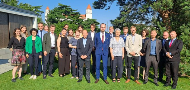 Gruppenbild mit etwa 20 Personen auf einer Wiese