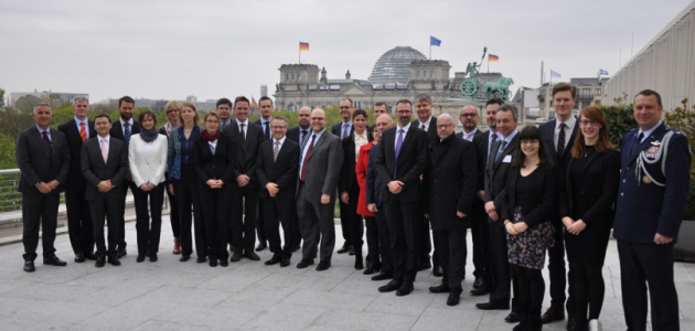 Eine Gruppe von Menschen steht auf dem Dach der US-Botschaft in Berlin; im Hintergrund ist der Deutsche Bundestag sowie davor die Quadriga auf dem Brandenburger Tor sichtbar.